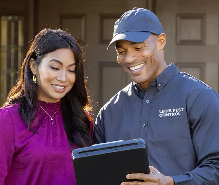 Technician speaking with a home owner in front of a house | Leo's Pest Control serving the Bristol and Johnson City TN area